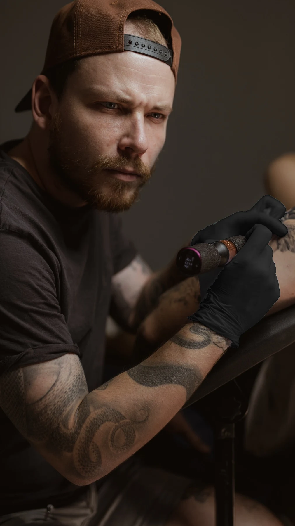 Ivan con su máquina de tatuar y guantes negros